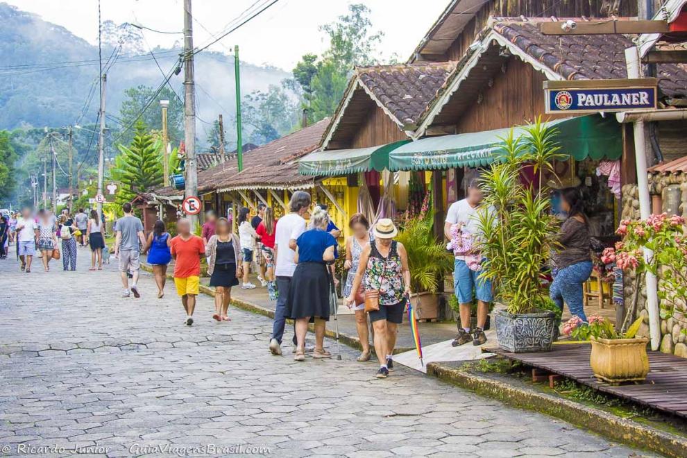 Imagem de turistas caminhando pelas ruas conhecendo o comércio da Vila de Maringá.